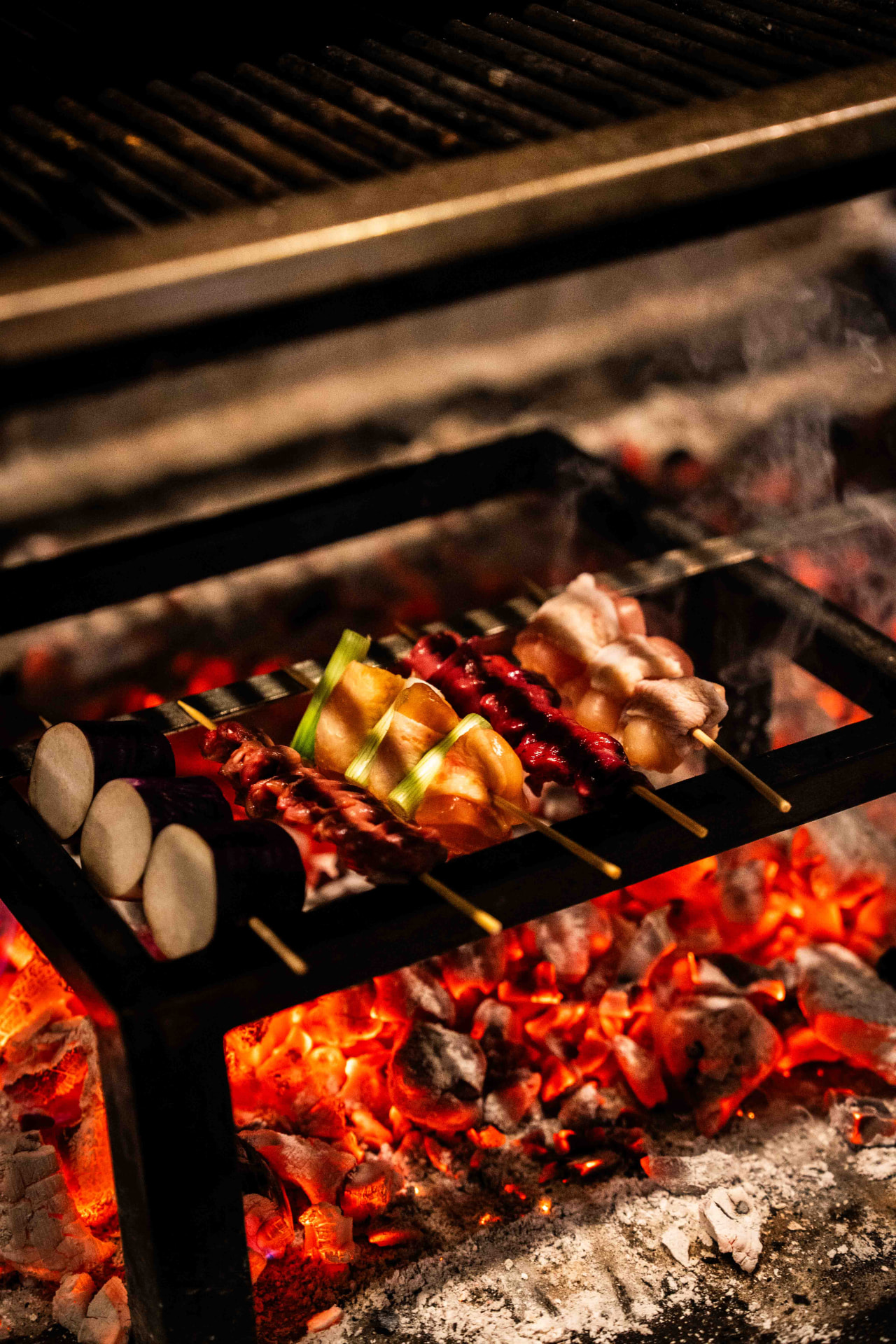 Yakitori-spiesen boven gloeiende houtskool